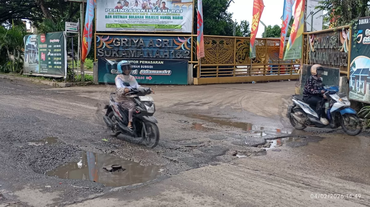 Tampak luas lokasi jalan di depan Indomaret Cadas-Kukun dengan kondisi aspal yang tidak merata pasca pekerjaan galian pipa air.