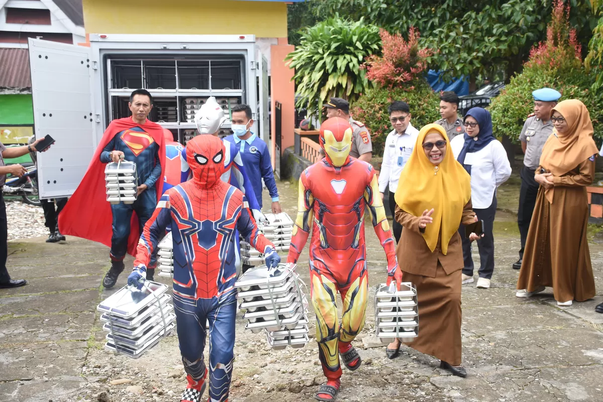 Penyaluran Makan Bergizi Gratis oleh Dapur SPPG Polres Bulukumba kepada siswa di Kecamatan Bulukumpa dengan karyawan berkostum superhero.
