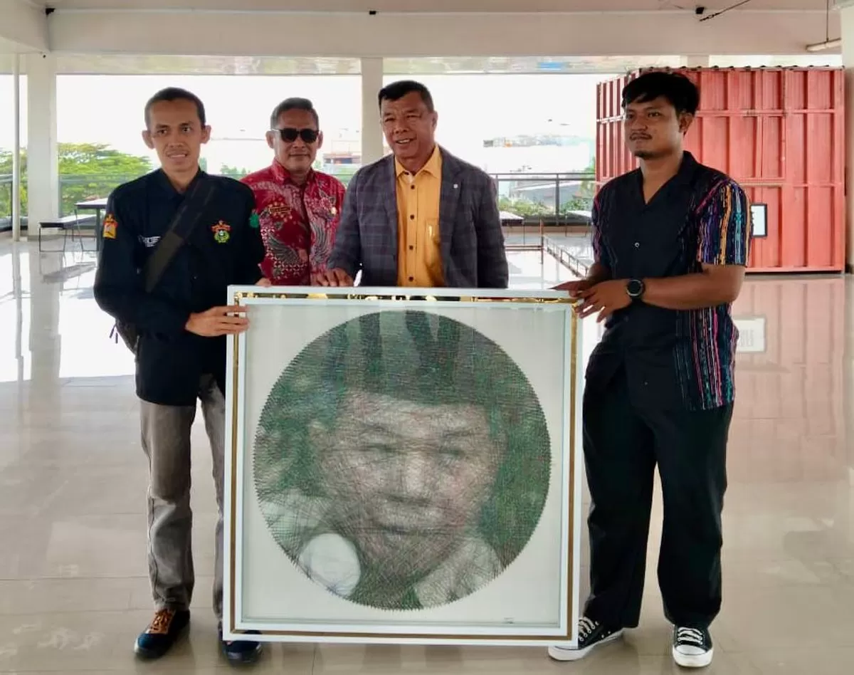 Bupati Bulukumba Andi Muchtar Ali Yusuf menerima lukisan benang dari Kasman Tubillahi di Gedung Pinisi Bulukumba, Kamis (22/1/2026).