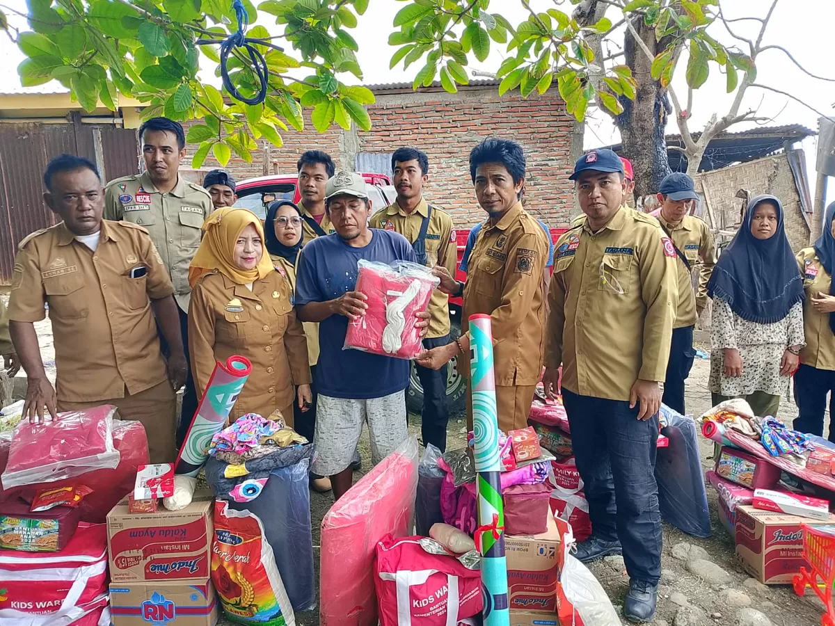 Kepala Dinas Sosial Bulukumba Hj. Darmawati menyerahkan bantuan kepada korban terdampak abrasi air laut kepada warga Lingkungan Kalimassang, Kelurahan Mariorennu.