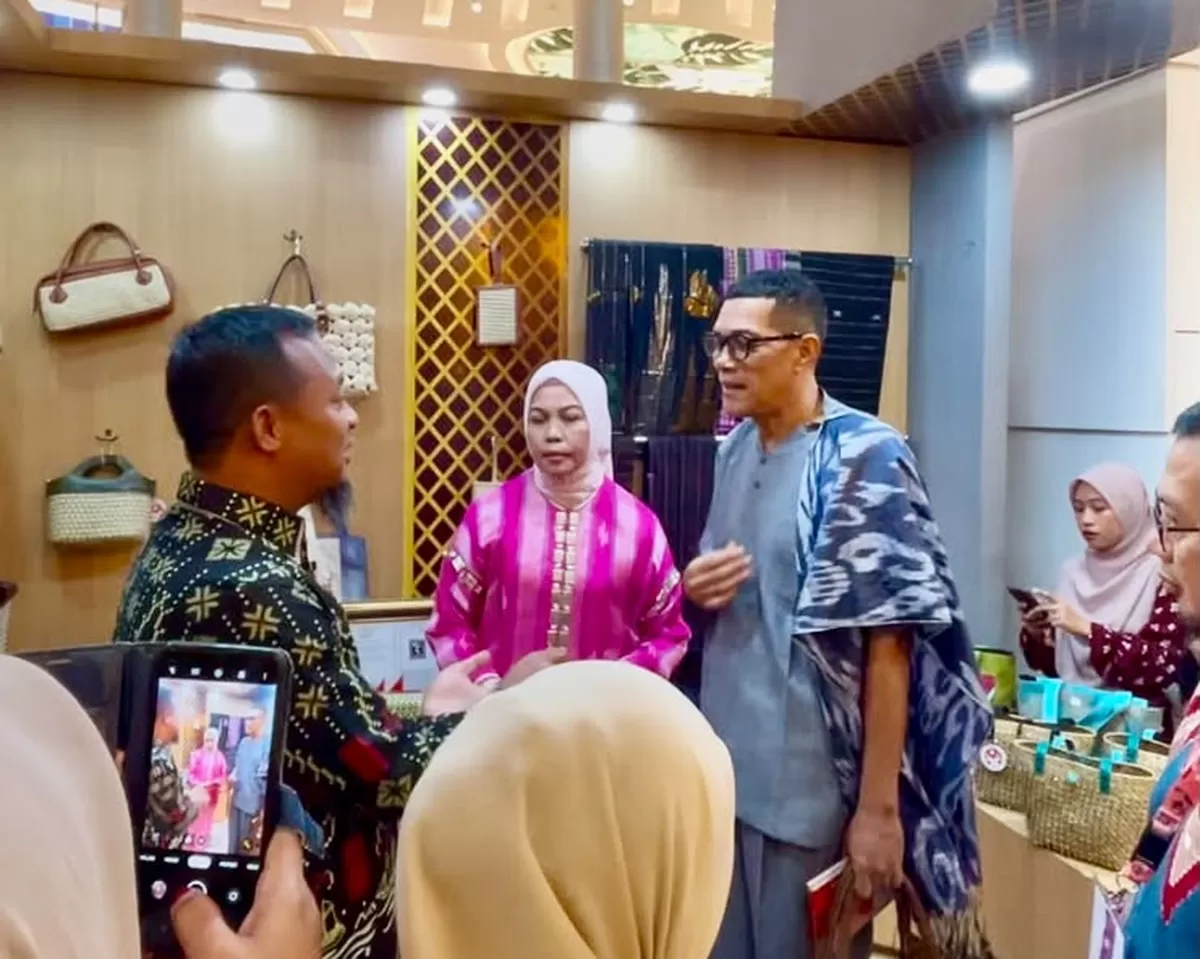 Gubernur Sulsel Andi Sudirman Sulaiman membeli miniatur Kapal Pinisi karya perajin UKM Adiba Souvenir Tana Beru saat mengunjungi stand Dekranasda Bulukumba pada penutupan HUT Dekranas ke-46 di Makassar, Minggu (12/7/2026).