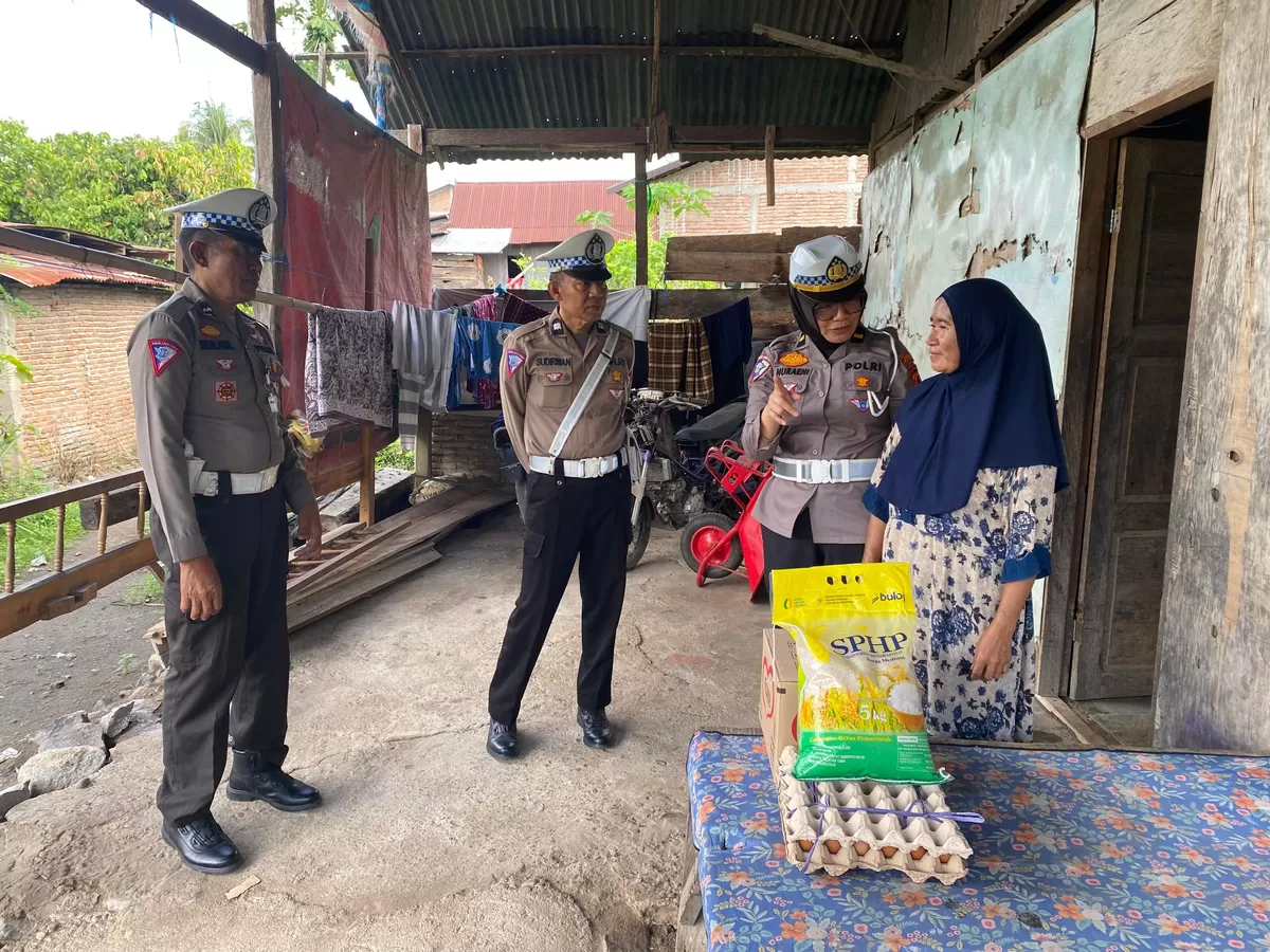 Kanit Kamsel Sat Lantas Polres Bulukumba, Ipda Nuraeni, bersama personel Unit Kamsel menyerahkan paket sembako kepada Nurdiati usai memberikan edukasi keselamatan berlalu lintas dalam program Jumat Berkah di Desa Palambarae, Kecamatan Gantarang.