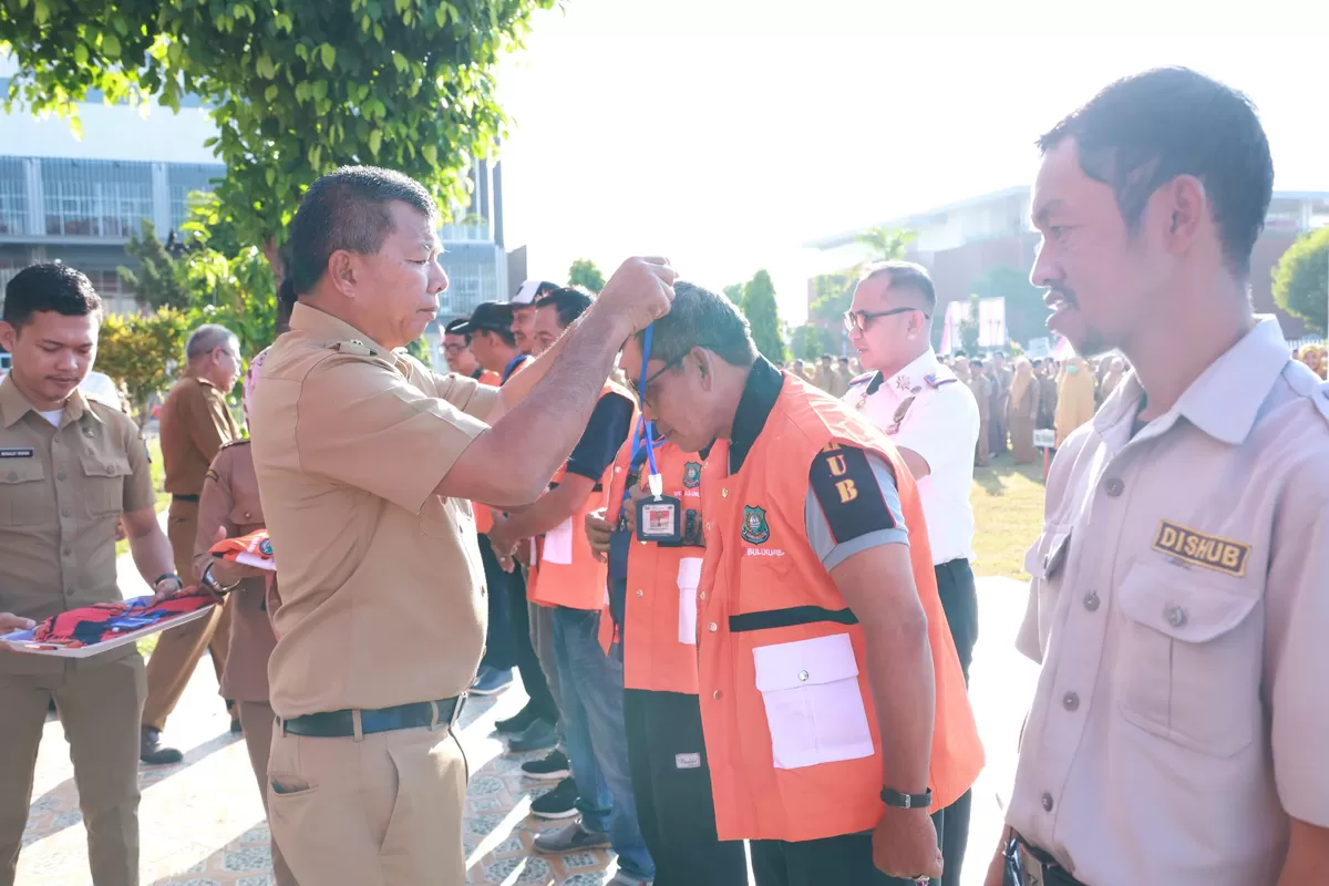 Bupati Bulukumba Andi Muchtar Ali Yusuf memasangkan rompi kepada petugas parkir tepi jalan dalam Apel Gabungan OPD di Halaman Kantor Bupati Bulukumba, Senin (10/8/2026).