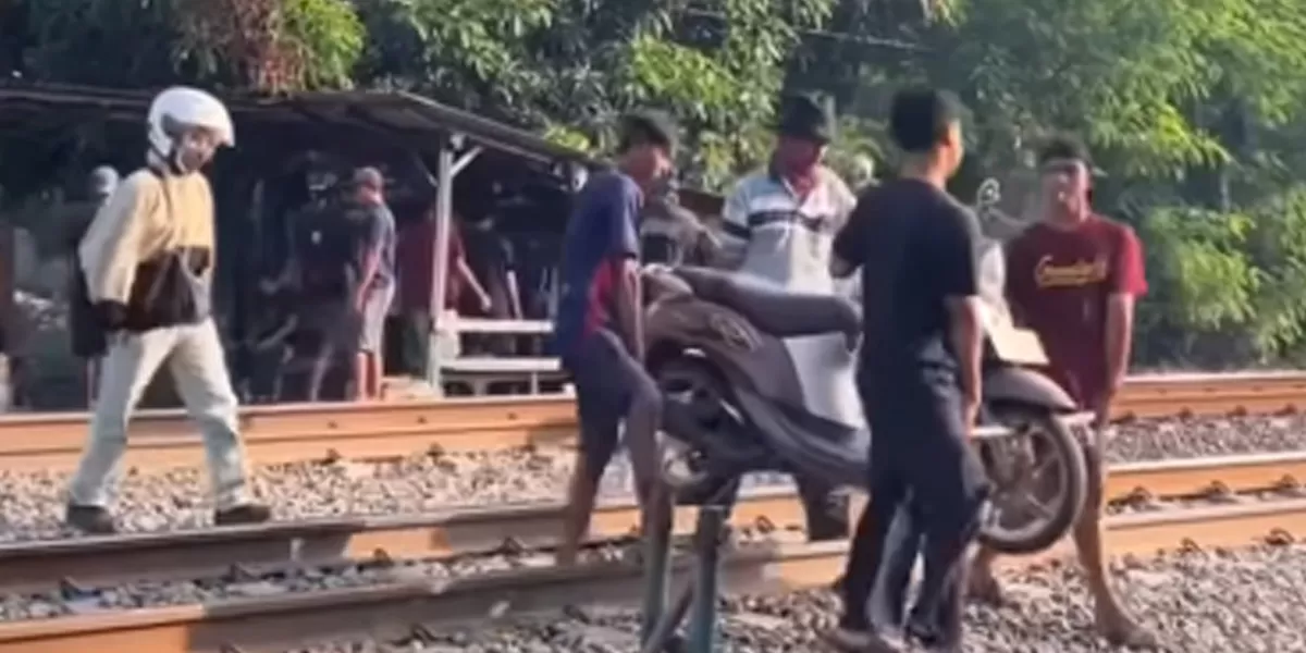 Salah satu warga menggunakan jasa angkat motor di lintasan rel Cibitung, Bekasi.  (instagram/liputancikarang)