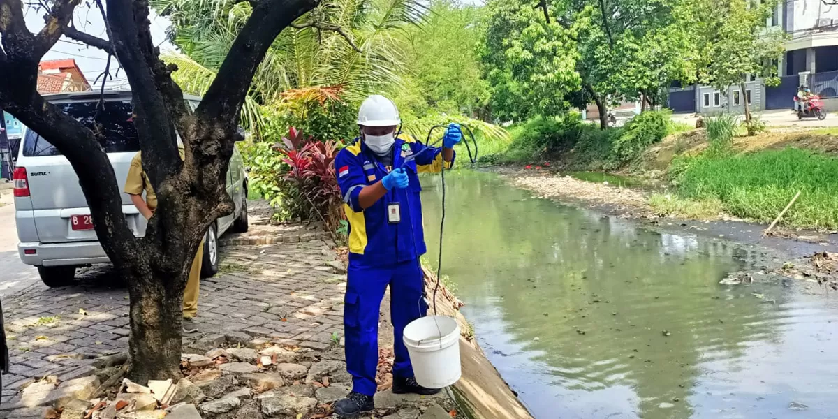 Tim DLH Kota Bekasi mengambil sampel air di aliran Kali Rawalumbu untuk pemeriksaan laboratorium. (dok pemkot bekasi)