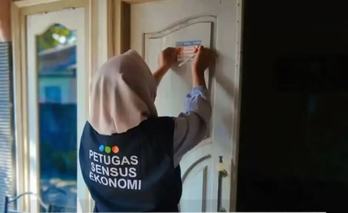 Petugas Sensus Ekonomi menempelkan stiker, menunjukkan kalau rumah tersebut sudah di data