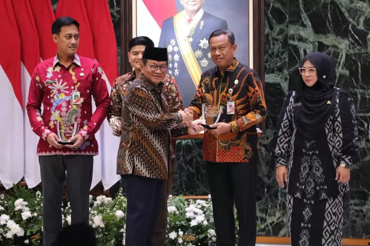 Gubernur DKI Jakarta Pramono Anung menyerahkan penghargaan yang diterima Wali Kota Administrasi Jakarta Timur, Munjirin, dalam kegiatan penunaian ZIS bagi para pejabat dan pimpinan BUMD di Balai Agung, Balaikota, Jakarta Pusat, Kamis (5/3/2026). (f: Ist)