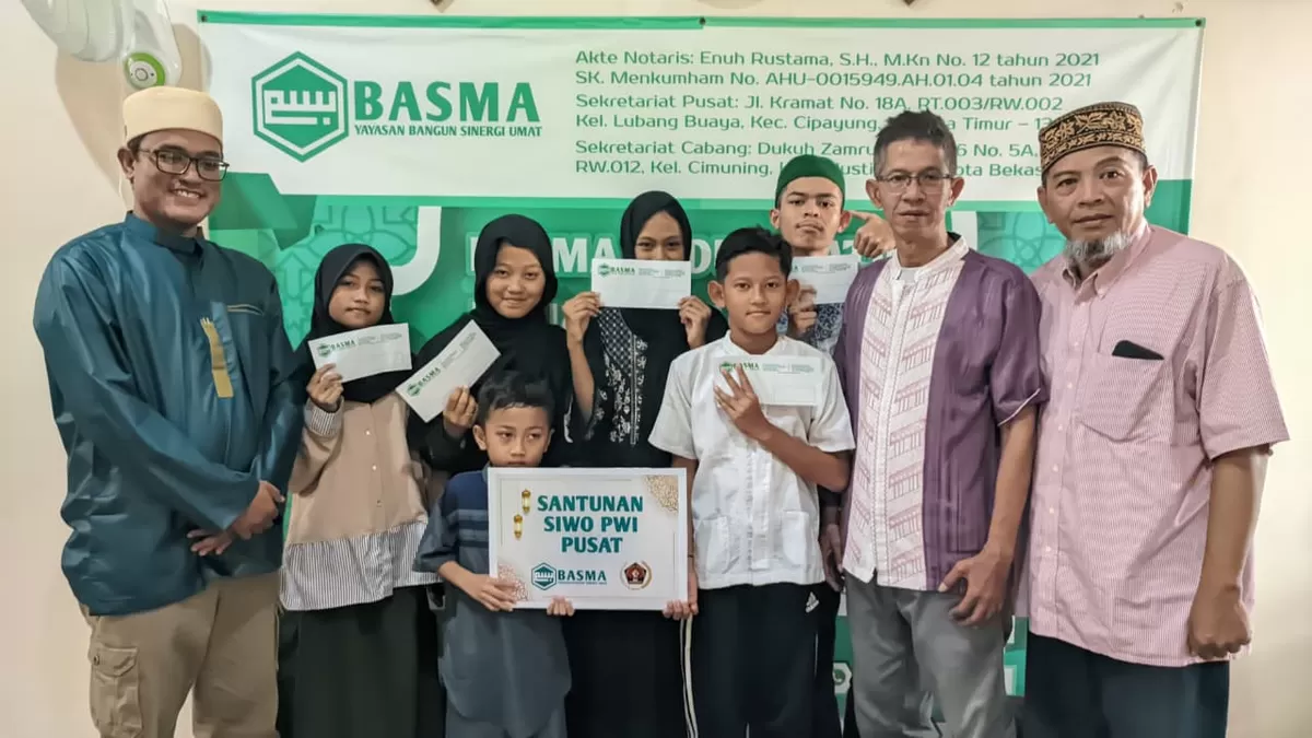 Ketua SIWO PWI Pusat, Suryansyah, foto bersama pengurus Yayasan Bangun Sinergi Umat (BASMA) beserta anak-anak yatim, kaum dhuafa, dan disabilitas. (f: istimewa)