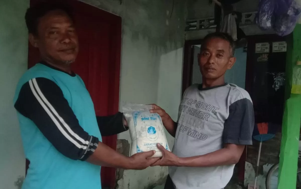 Relawan paguyuban Merah Putih Kaliprau (kiri) saat menyerahkan zakat fitrah kepada penerima manfaat, pada Kamis, 19 Maret 2026. (f: istimewa)