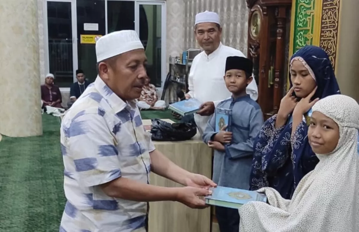 Kakanwil Kemenag Riau Muliardi menyerahkan penghargaan bagi anak-anak yang giat tadarus selama Ramadan, di Masjid Paripurna Kelurahan Ijtihadul Muslimin, Kamis malam, 19 Maret 2026. (f: istimewa)