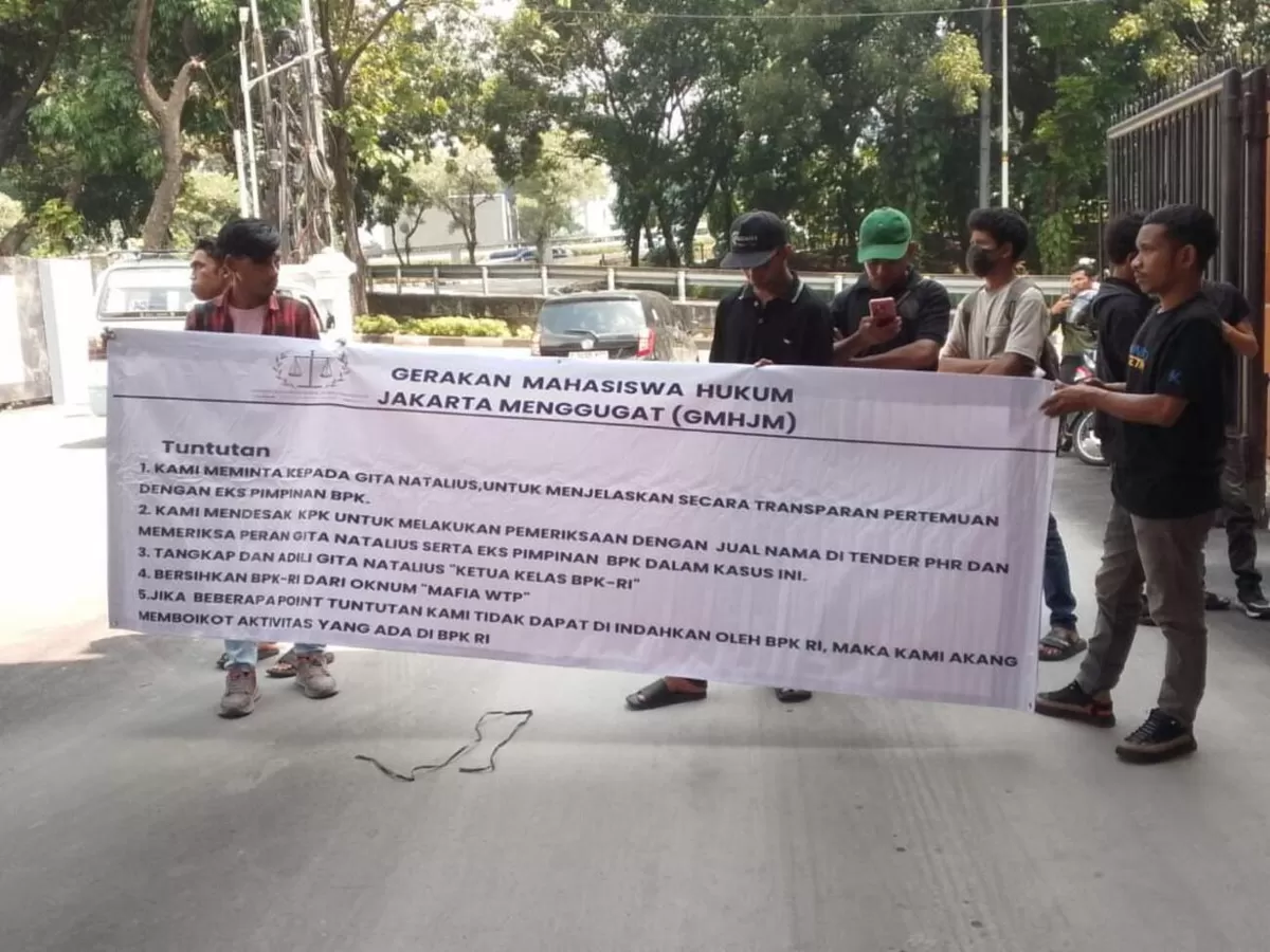 Saat unjuk rasa di Gedung BPK RI di Jakarta, pada Kamis 21 Mei 2026, massa GMHJM terlihat membawa spanduk berisikan lima tuntutan, salah satu poin berbunyi: Tangkap dan Adili Gita Natalius 'Ketua Kelas BPK RI'.