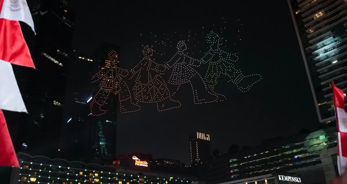 Pesan &ldquo;PRAY FOR NTT&rdquo; membuka pertunjukan 1.500 drone dalam Malam Merdeka di Bundaran HI. Setelahnya, cahaya drone membentuk Soekarno-Hatta, Merah Putih, dan cita-cita Indonesia. (Dok. Kementerian Ekraf)
