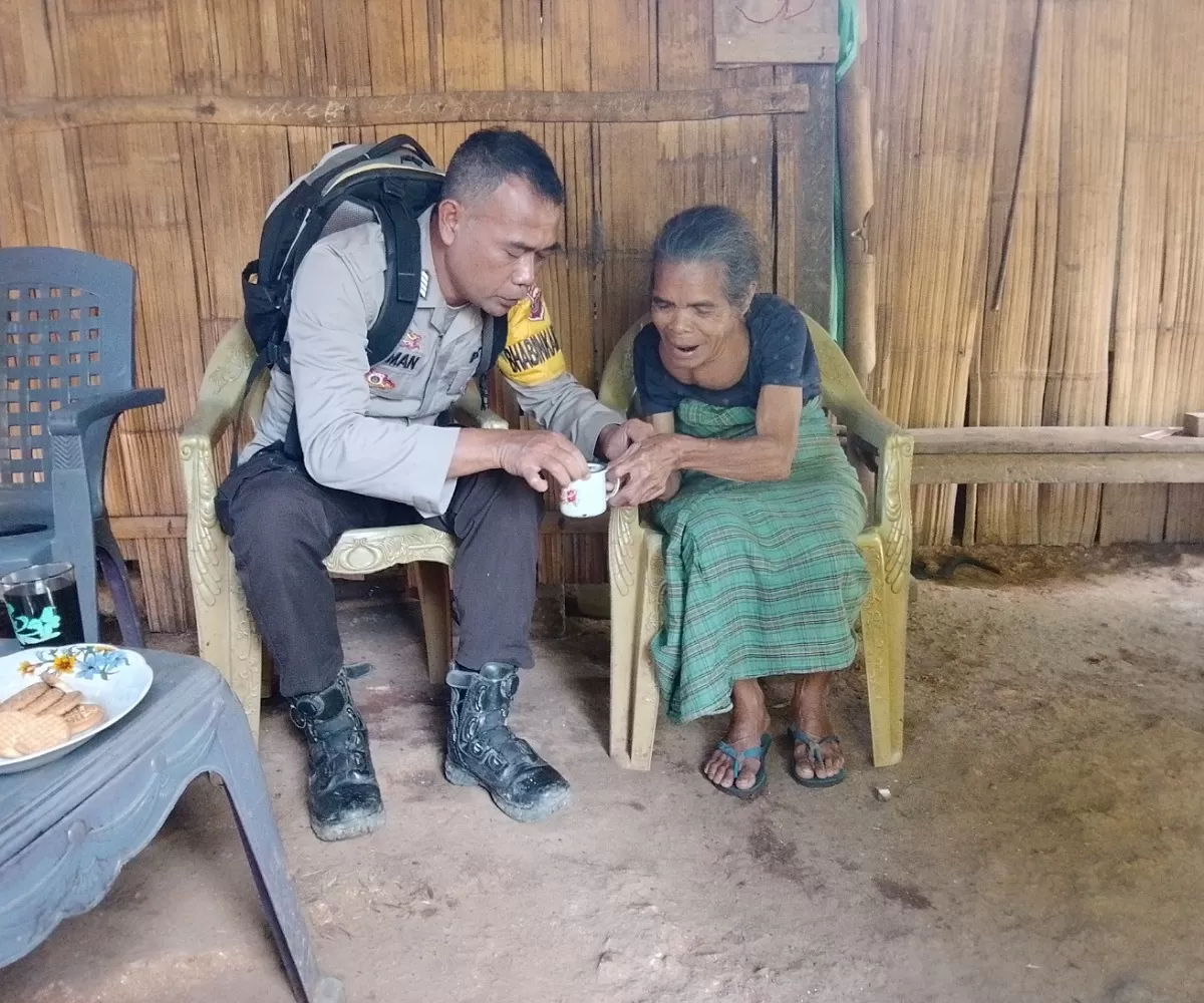 Aipda Sukiman saat mendinginkan air panas untuk diminum seorang lansia di Elar-Manggarai Timur (Foto:J.S-Idenusantara.com)