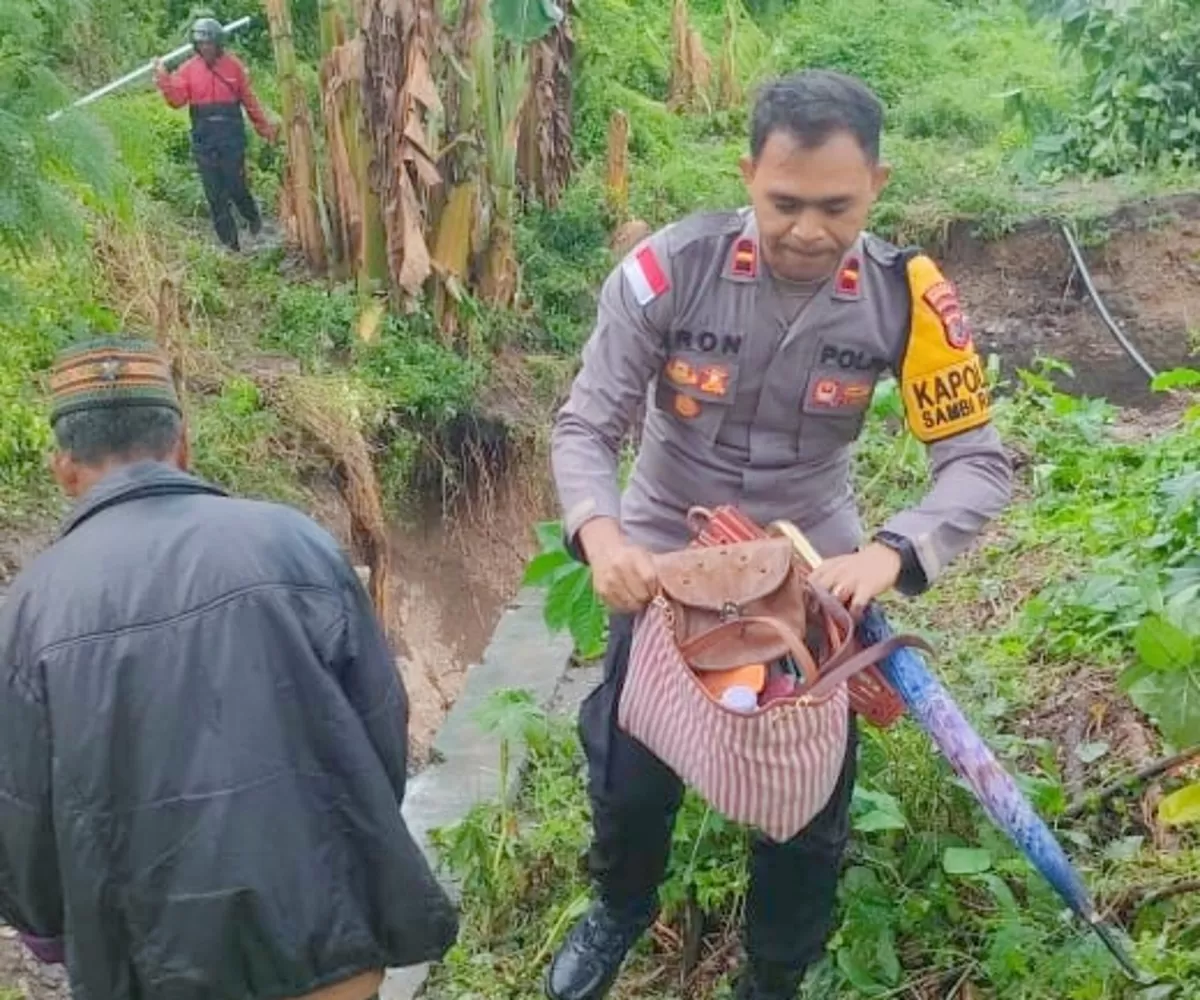 Ipda Iron, Kapolsek Sambi Rampas sedang me membantu warga yang lewati  jalur Pantura Pota-Riung yang putus