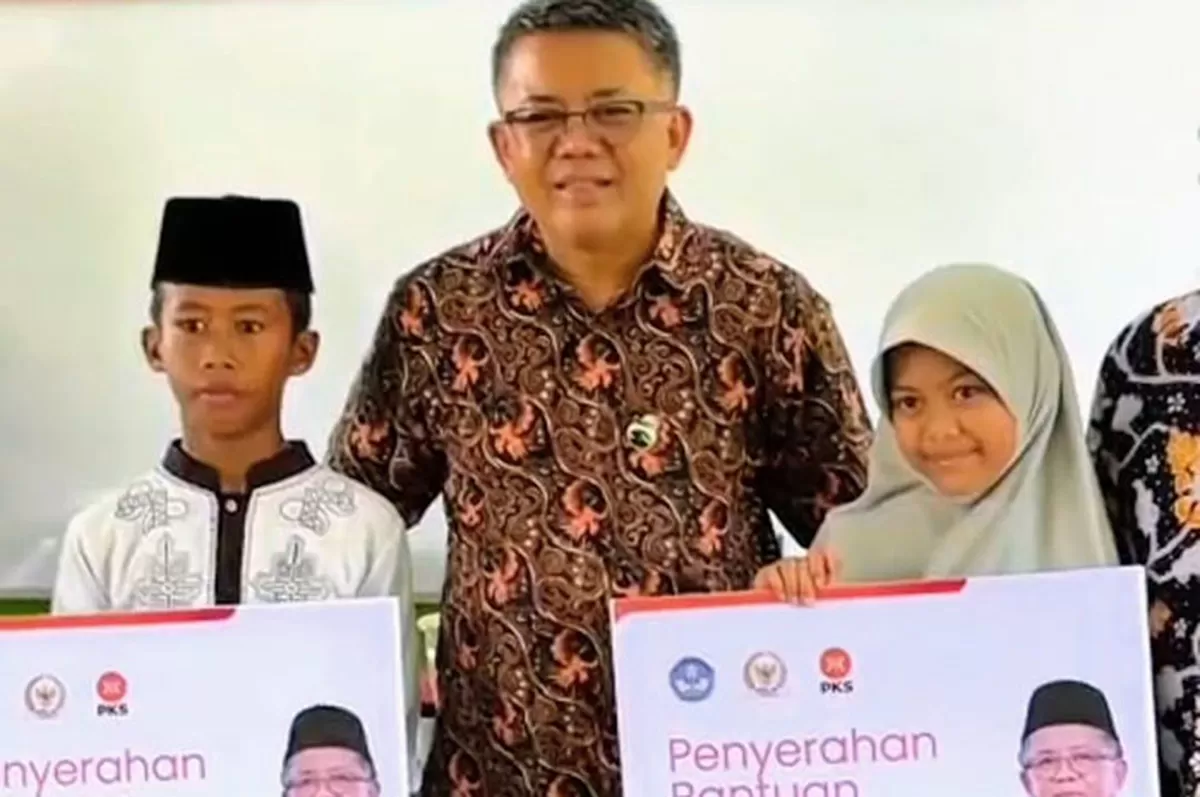 Anggota DPR RI Fraksi PKS, Muhamad Sohibul Iman, berfoto bersama dua siswa penerima bantuan PIP di Kecamatan Cipedes Kota Tasikmalaya, Kamis 8 Januari 2026. (Dok. Asep M.S)