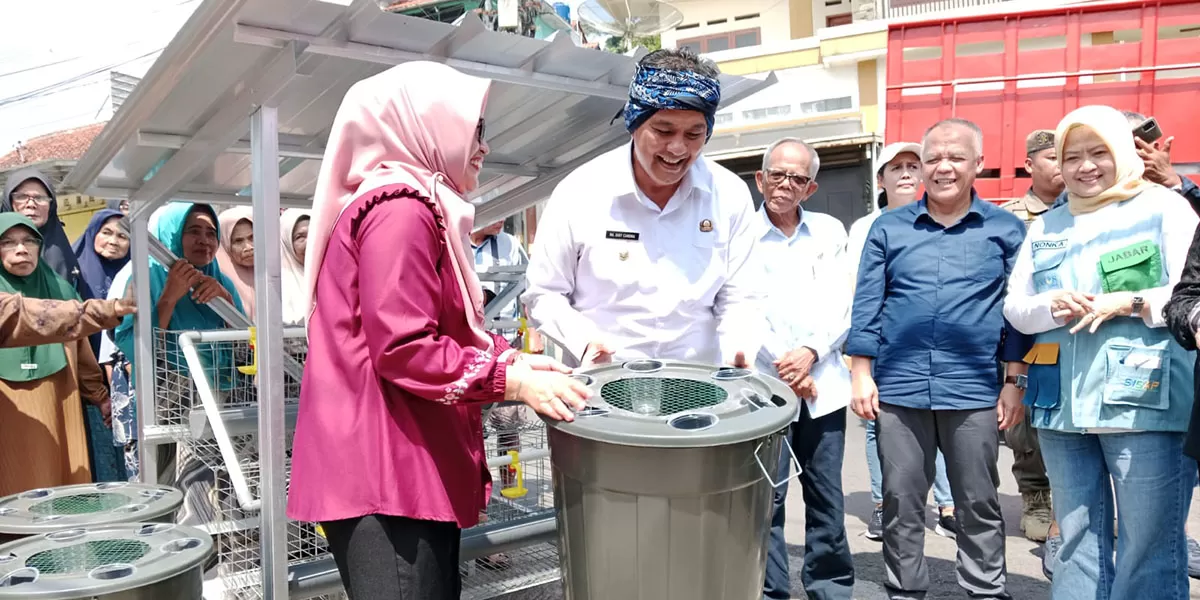 Kepala Dinas Sosial Provinsi Jawa Barat, Noneng Komara Nengsih, S.E., bersama Wali Kota Tasikmalaya Diky Chandra menyerahkan bantuan satu unit kandang ayam petelur secara simbolis dalam kegiatan Kampung Sosial di Kelurahan Tuguraja, Kecamatan Cihideung, Kota Tasikmalaya, Selasa (10/02/2026). (Dok. Asep M.S)