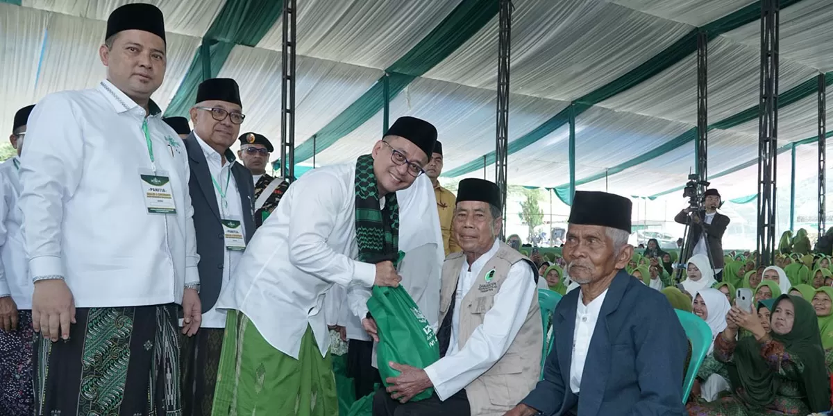 Bupati Tasikmalaya, Dr.H. Cecep Nurul Yakin, S.Pd, M.Ap didampingi pengurus Pondok Pesantren Darussalam Rajapolah, menyerahkan bantuan paket sembako kepada salah seorang warga Nadliyyin pada acara Harlah NU. (Dok. DFK)
