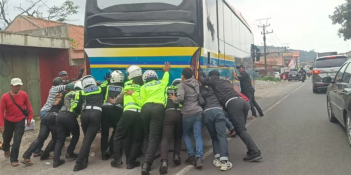 Aksi petugas Polres Tasikmalaya Kota yang tergabung dalam tim ganjal saat membantu kendaraan pemudik mengalami overheat dan mogok. (Dok. AMS)