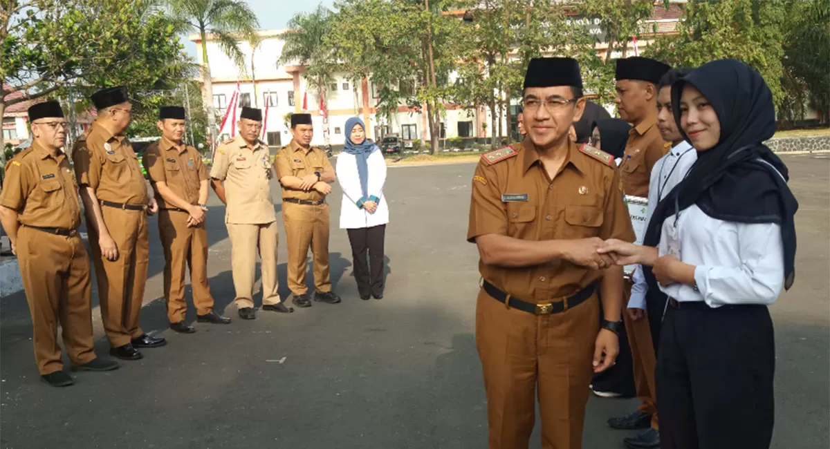 Sekda menyerahkan kartu BPJS Ketenagakerjaan untuk pekerja rentan, serta kartu BPJS Ketenagakerjaan dan Surat Izin Praktik (SIP) bagi tenaga kesehatan dan tenaga medis peserta magang nasional. (Dok. DFK)