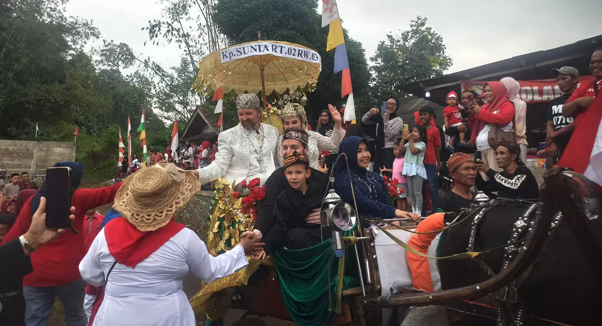 Diarak warga di atas kereta kuda, keluarga Shaahid Bateson asal Kanada menyapa ribuan warga seusai pawai Jampana di Desa Cikunir, Kecamatan Singaparna, Kabupaten Tasikmalaya, Senin (17/8/2026). (Dok. DFK)