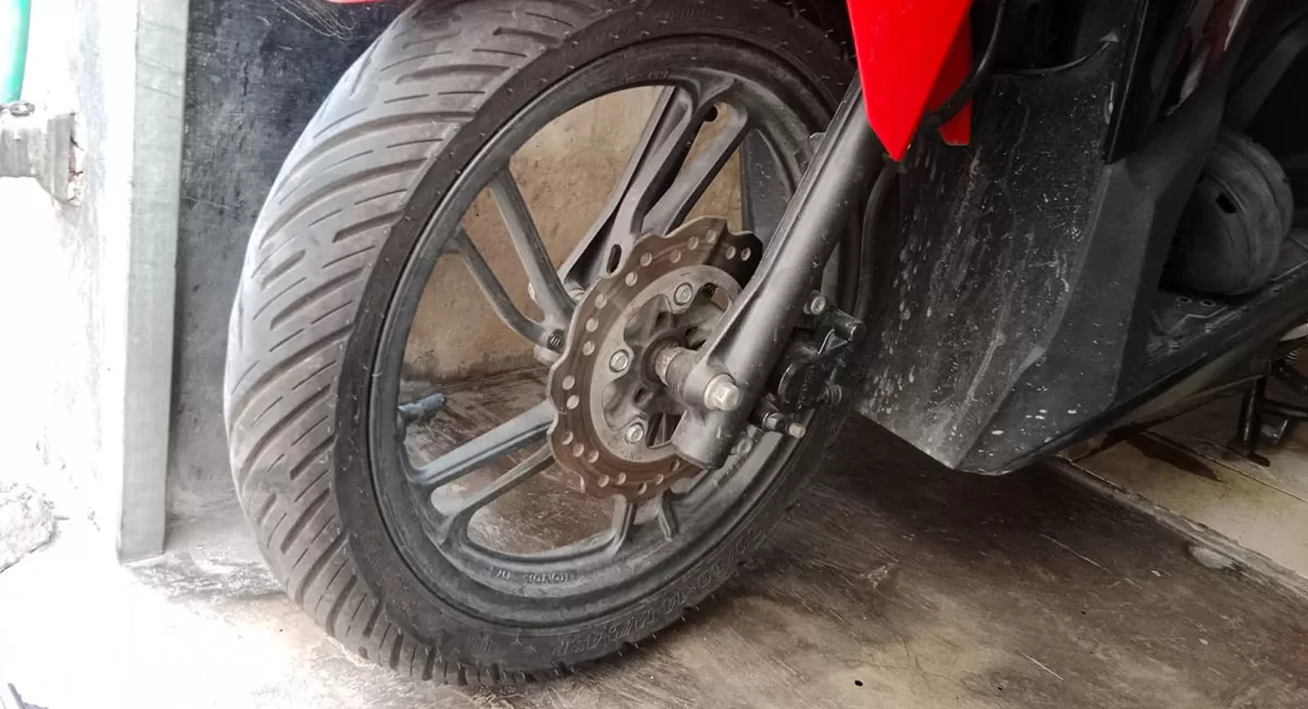 Lima tanda ban motor harus segera diganti antara lain alur menipis, menyentuh TWI, retak, motor oleng, dan muncul benjolan. (Dok. Promedia)