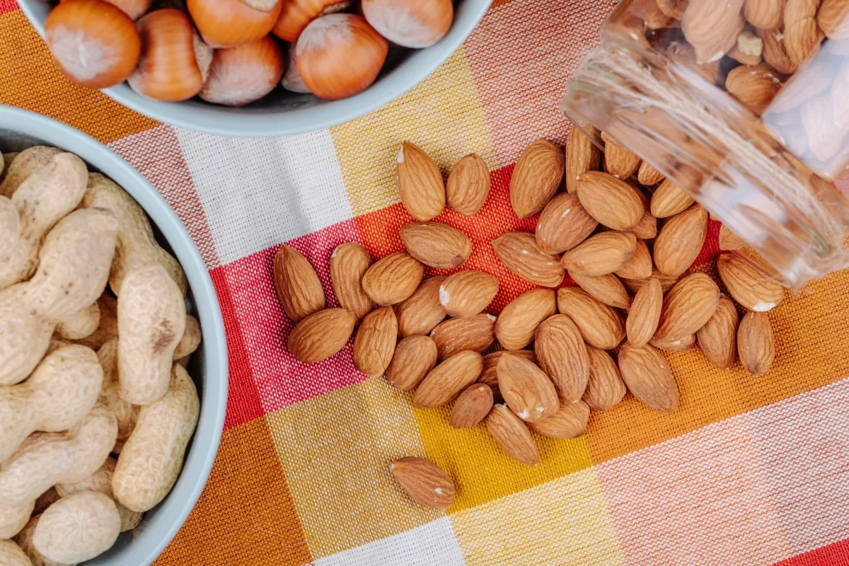 Ilustrasi almond dan kacang tanah sebagai camilan sehat dengan kandungan protein dan lemak baik untuk jantung (Magnific)