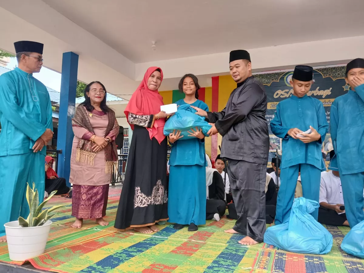Kepala Sekolah SMPN 12 Batam Dra Nurmi menyerahkan secara simbolis bantuan paket sembako kepada anak yatim dan kaum dhuafa. (Muhammad Kamil)