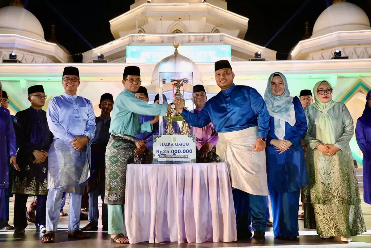 Walikota Batam Amsakar Achmad, menyerahkan piala bergilir dan hadiah kepada kafilah dari Kecamatan Sagulung saat malam penutupan MTQH XXXIV tingkat Kota Batam.(Foto:Diskominfo Batam).