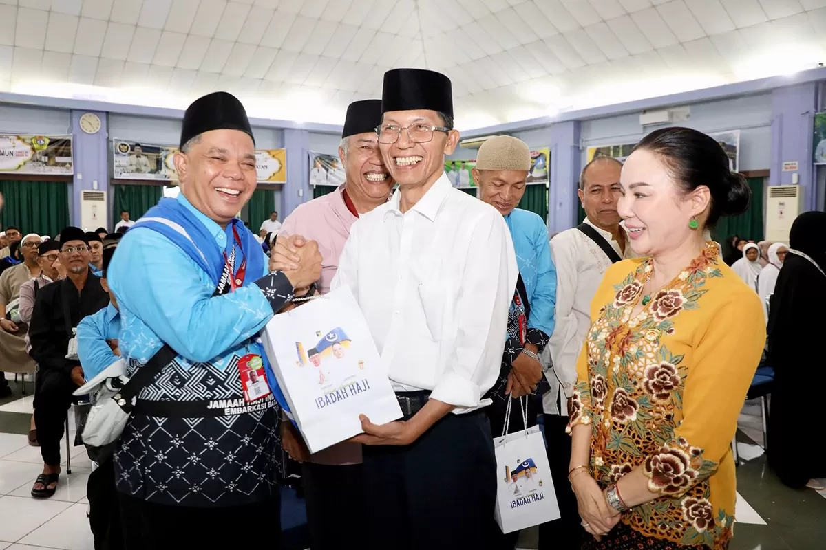 Walikota Batam Amsakar Achmad didampingi Wakil Walikota Batam Li Claudia Chandra meberikan bingkisan saat melepas Calon Jemaah haji berangkat ke Tanah Suci. (Foto:Diskominfo Batam)
