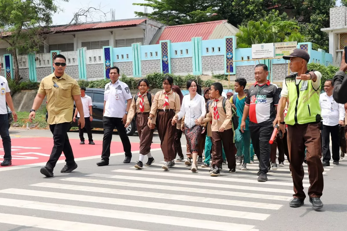  Wakil Walikota Batam, Li Claudia Chandra, membimbing siswa SDN 001 Batam Kota mempraktikan cara menyeberangi jalan lewat ZoSS. (Foto:Diskominfo Batam)