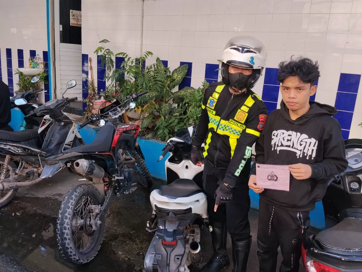 Personel Polsek Sekupang, photo bersama karyawan dan pemilik bengkel usai sosialisasi knalpot brong. (Humas Polresta Barelang)
