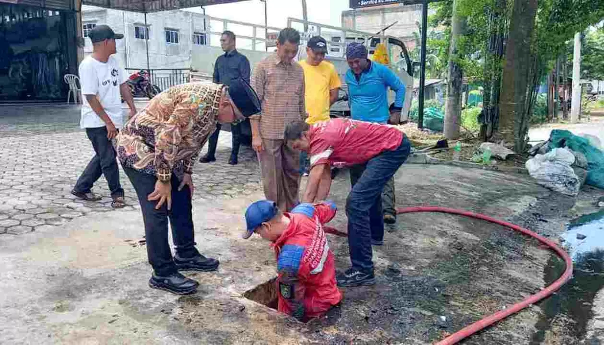 Walikota Lis bersama petugas kebersihan gotong royong membersihkan drainase tersumbat sampah dan kabel optik. (Foto: Diskominfo Tanjungpinang)