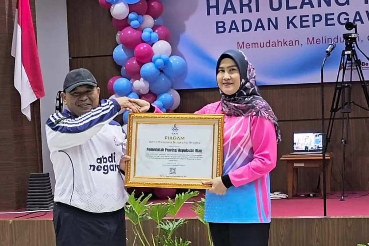 Kepala BKD Provinsi Kepri, Yeny Trisia Isabella saat menerima penghargan Adhi Manawa Nugraha Utama dari Kepala Kantor Regional XII BKN Pekanbaru, Purjiyanta pada peringatan HUT ke-78 BKN. (Foto: BKD Kepri)