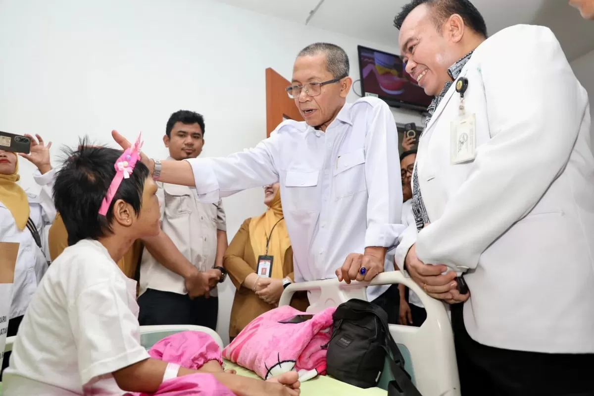 Wali Kota Batam Amsakar Achmad mengusap kepala dan memberikan semangat kepada RAL, bocah berusia 9 tahun yang sedang menjalani pemulihan di RSUD Embung Fatimah. (Humas Diskominfo Batam)
