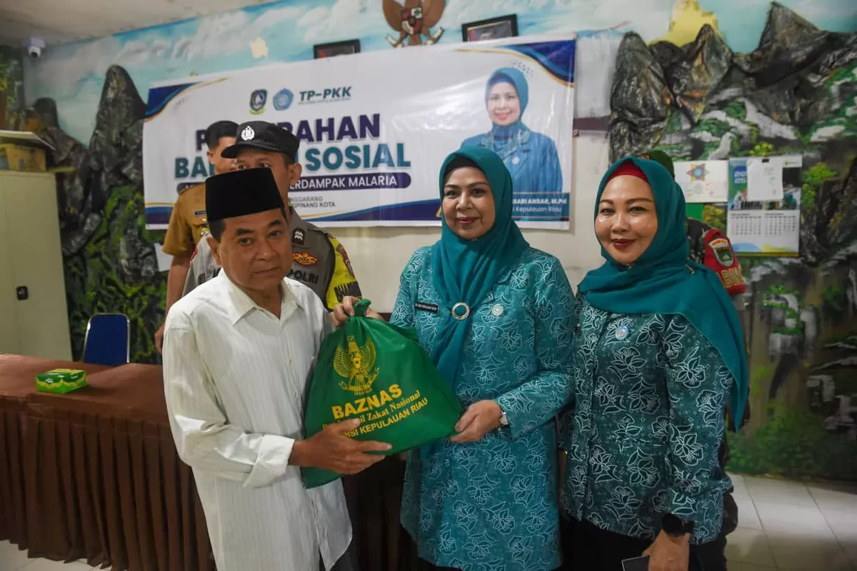 Ketua TP PKK Kepri, Dewi Kumalasari Ansar bersama Ketua TP PKK Kota Tanjungpinang Yuniarni Pustoko Weni saat menyerahkan bantuan. (Foto:Diskominfo Kepri) 