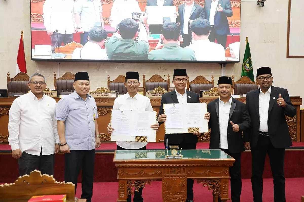 Walikota Batam Amsakar Achmad, bersama pimpinan dan anggota DPRD Batam menunjukkan dokumen pengesahan Perda PSU usai Rapat Paripurna. (Foto:diskominfo Batam) 