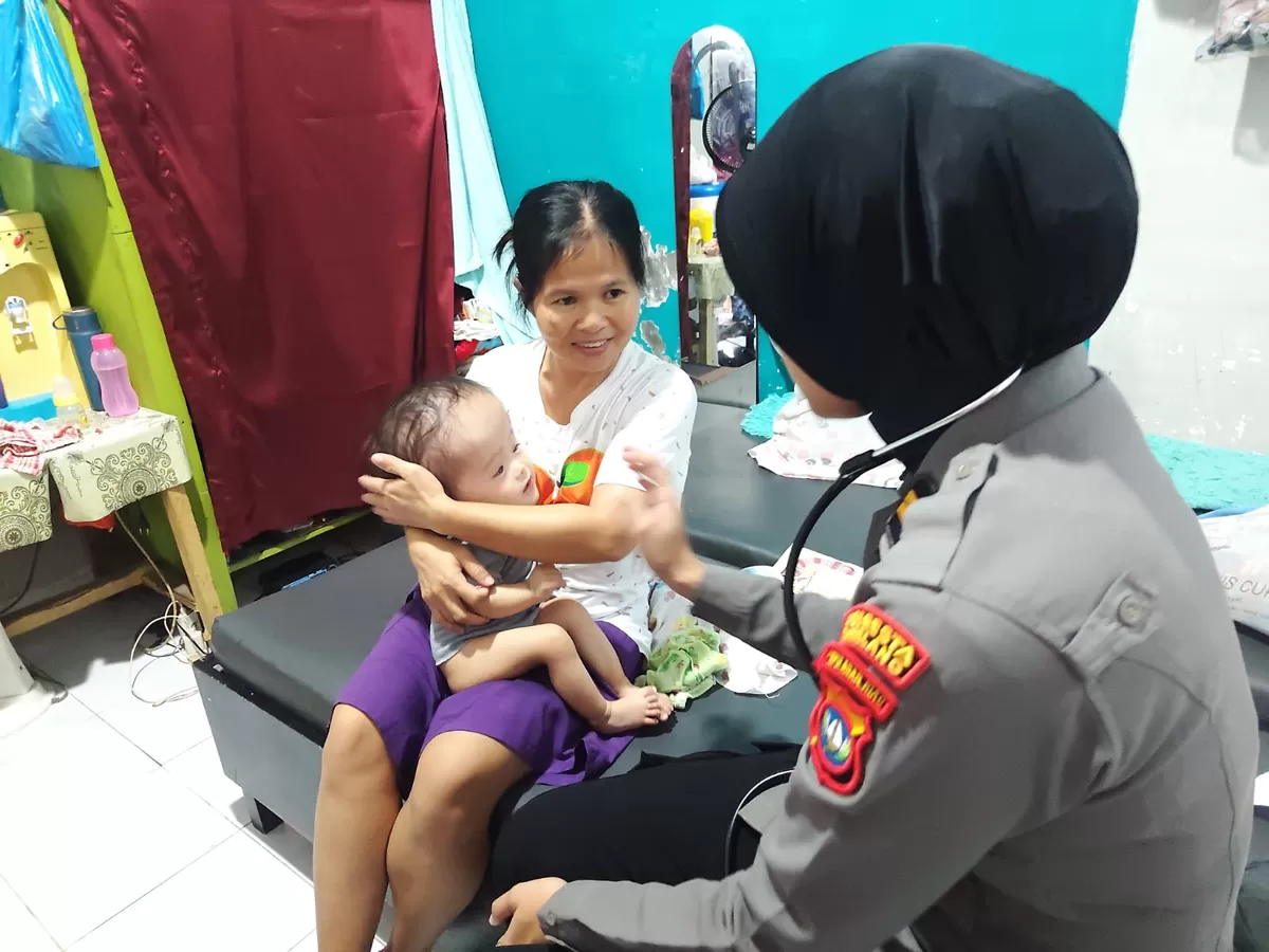 Tim medis yang dipimpin langsung Kasidokkes Polresta Barelang, saat memeriksa kesehatan Helengna, seorang bayi yang menderita hidrosefalus dikediamannya. (Humas Polda Kepri)