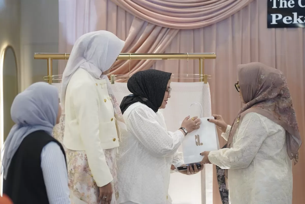 Pelaksana Tugas (Plt) Ketua Dekranasda Provinsi Riau, Adrias Hariyanto (tengah), secara simbolis menerima cinderamata berupa produk koleksi "Warna-warni Pekanbaru" saat menghadiri acara peluncuran di Jalan Arifin Ahmad, Pekanbaru. (Photo Ist.)