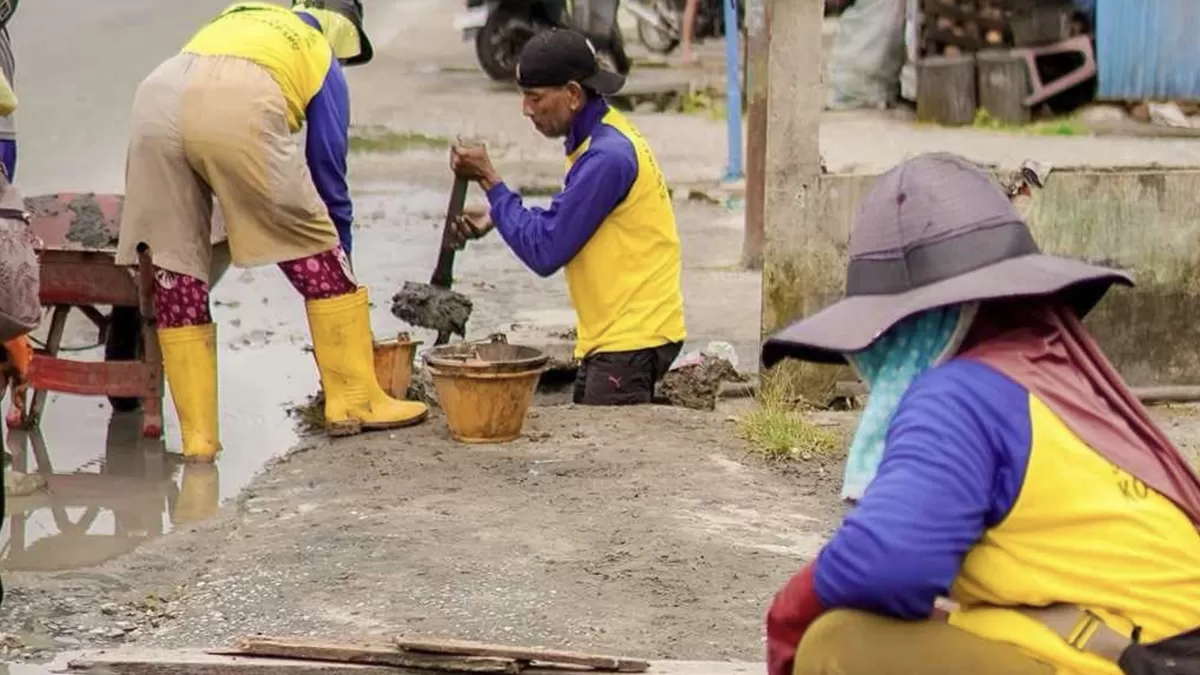 Para petugas dari Dinas PUPR Kota Pekanbaru tengah membersihkan endapan lumpur dan sampah dari dalam saluran drainase. (Photo Ist.)