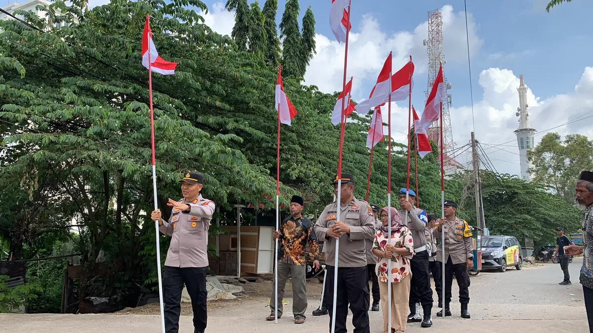 Jajaran Polsek Batam Kota turun langsung menyapa warga sekaligus membagikan Bendera Merah Putih. (Humas Polresta Barelang.)