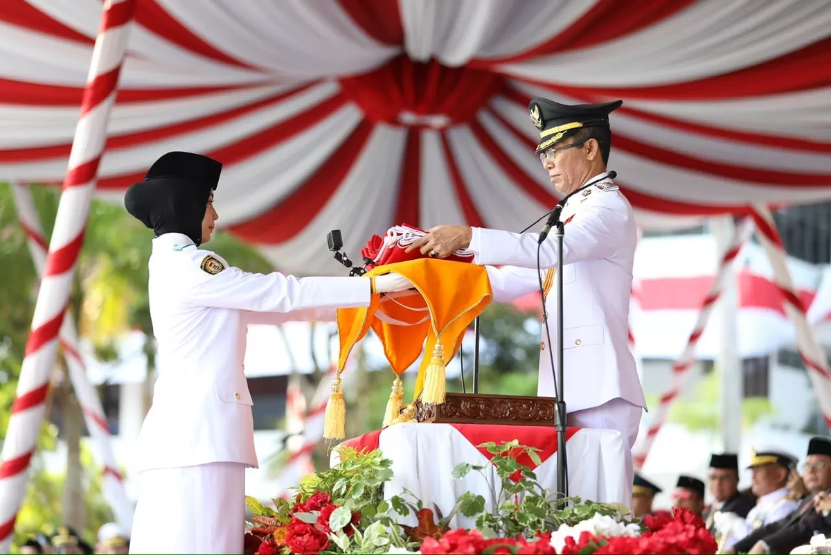 Wali Kota Batam, Amsakar Achmad, menyerahkan Bendera Merah Putih saat Upacara HUT ke-81 RI di Dataran Engku Putri, Batamcentre, Senin 17 Agustus 2026. (Humas Diskominfo Batam )