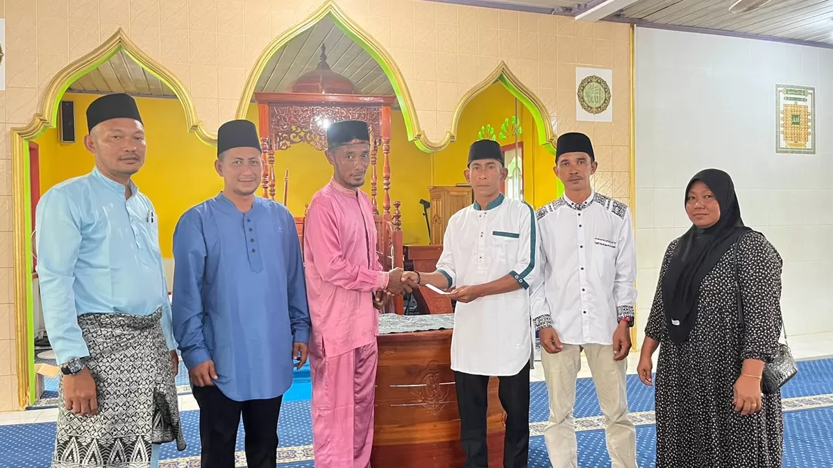 Penyerahan Santunan secara simbolis oleh pengurus Karang Taruna, Zaidi, di dampingi Kepala Desa Rewak, Deva Syafutra dalam acara Maulid Nabi Muhammad SAW 2448 H di Mesjid Al - Hijrah Lembah Rewak. (Ropi Kahardi )
