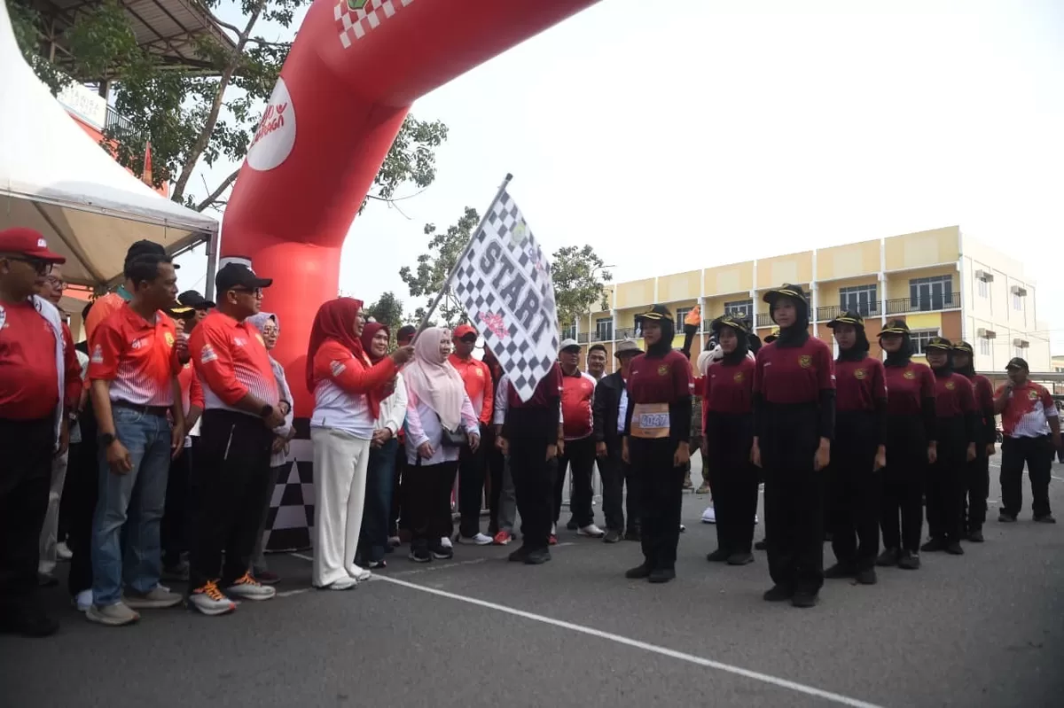Ketua TP PKK Provinsi Kepulauan Riau, Dewi Kumalasari, kibarkan bendera start lepas gerak jalan santai ,Minggu 23 Agustus 2026. (Humas Diskominfo Kepri )