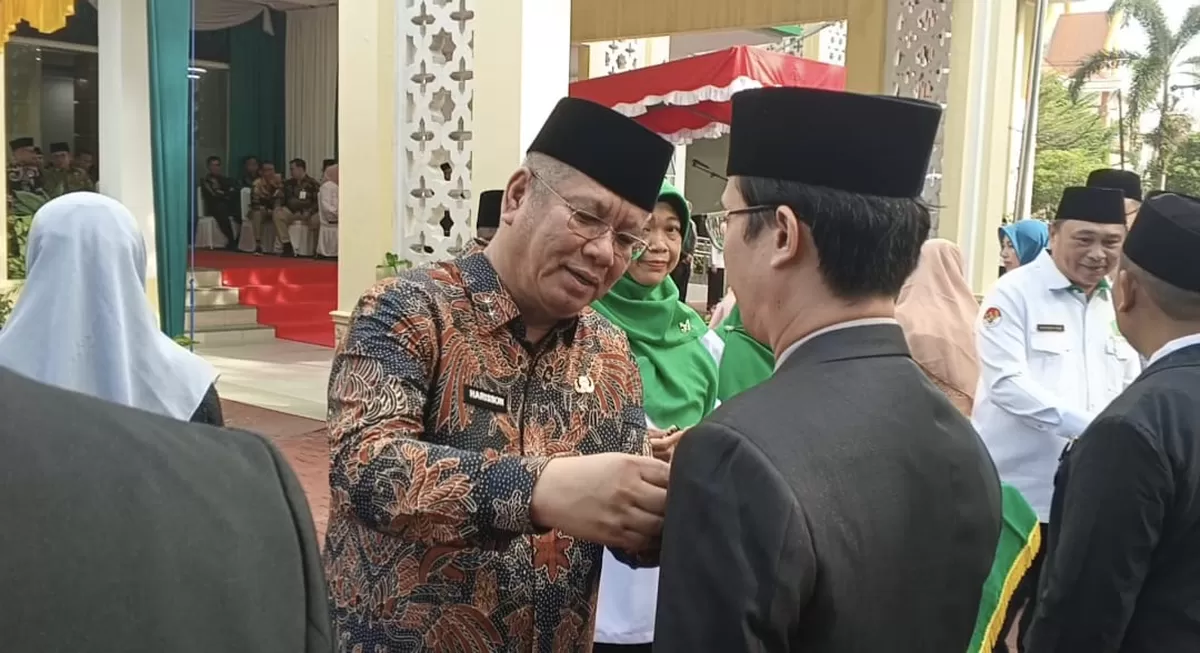 Sekda Kalbar Harisson didampingi Kakanwil Kemenag Kalbar Muhajirin Yanis menyematkan Lencana Karya Satya kepada ASN Kemenag Kalbar pada Upacara HAB ke-80 Kemenag di Halaman Kantor Kanwil Kemenag Kalbar, Sabtu (3/1/2026). (Wilhelmus Triputra)