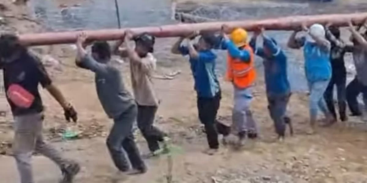 Warga dan Petugas PLN gotong royong menyeberangi sungai sambil membawa tiang listrik untuk desa terisolir di Aceh Tengah. (Dok. Instagram/serta_lia_gali)