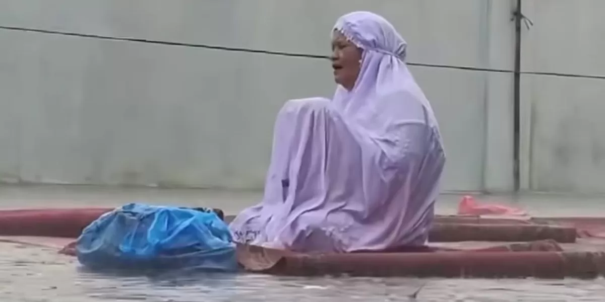 Momen seorang ibu yang terus berdoa meski hujan turun dengan deras. (Dok. Instagram/pekanbarutalks)