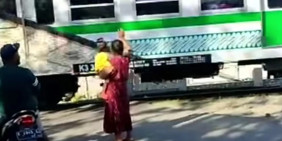 Viral video ibu-ibu di Wonogiri jadi relawan hentikan pengendara saat kereta akan melintas di perlintasan tanpa palang pintu. (Dok. Instagram/yesstory01)