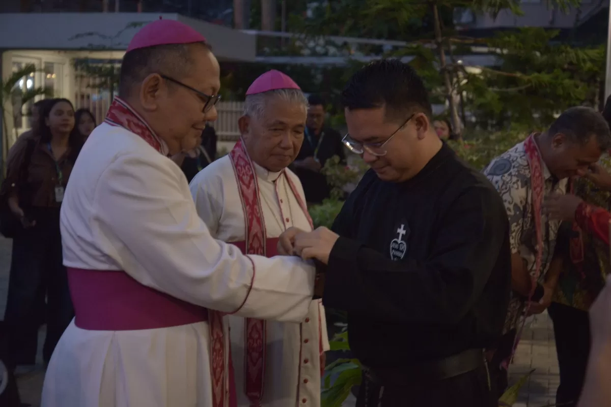 Ketua Komisi Komsos KWI, Mgr Agustinus Tri Budi Utomo (Mgr Didik) didampingi Uskup Agung Emeritus Keuskupan Agung Pontianak (KAP), Mgr Agustinus Agus menerima pengalungan syal motif Dayak dan pemasangan gelang dari Sekretaris KAP RP Aloysius Adiantus CP saat prosesi penyambutan peserta PKSN XIII.  (Komsos KAP)