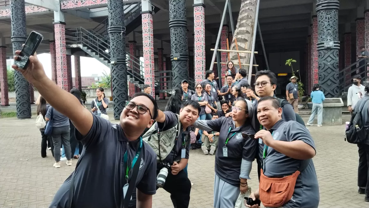 Di sela kunjungan ke Rumah Radakng (rumah adat Dayak) Pontianak, kreator PKSN XIII berswafoto untuk bahan konten. (Komsos KAP)
