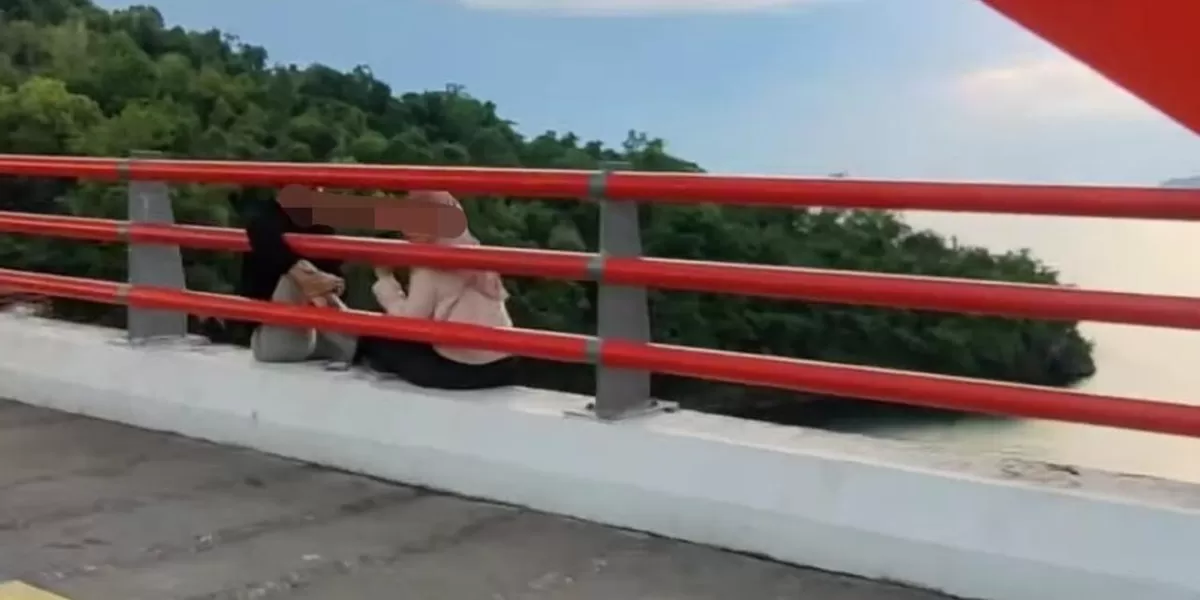 Viral pasangan muda-mudi ditegur warga karena duduk di tepi jembatan di Jayapura, Papua.  (Instagram/@eliantiandi)
